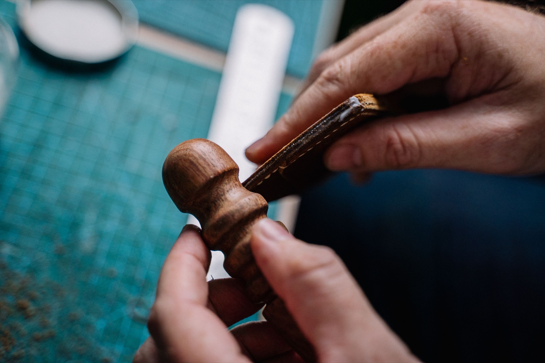 Close view of hands shaping a wooden object and its grain