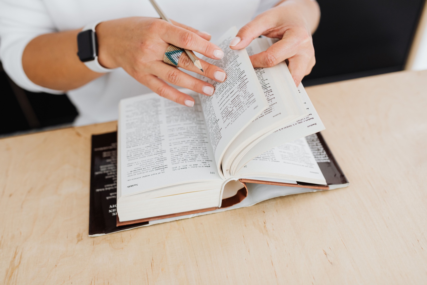 A person turning the pages of a dictionary