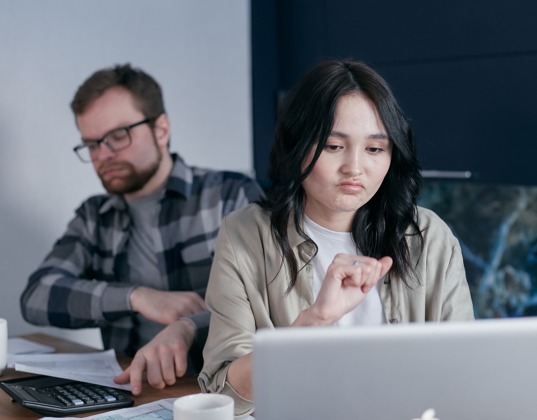 A couple looking worried while reviewing household bills