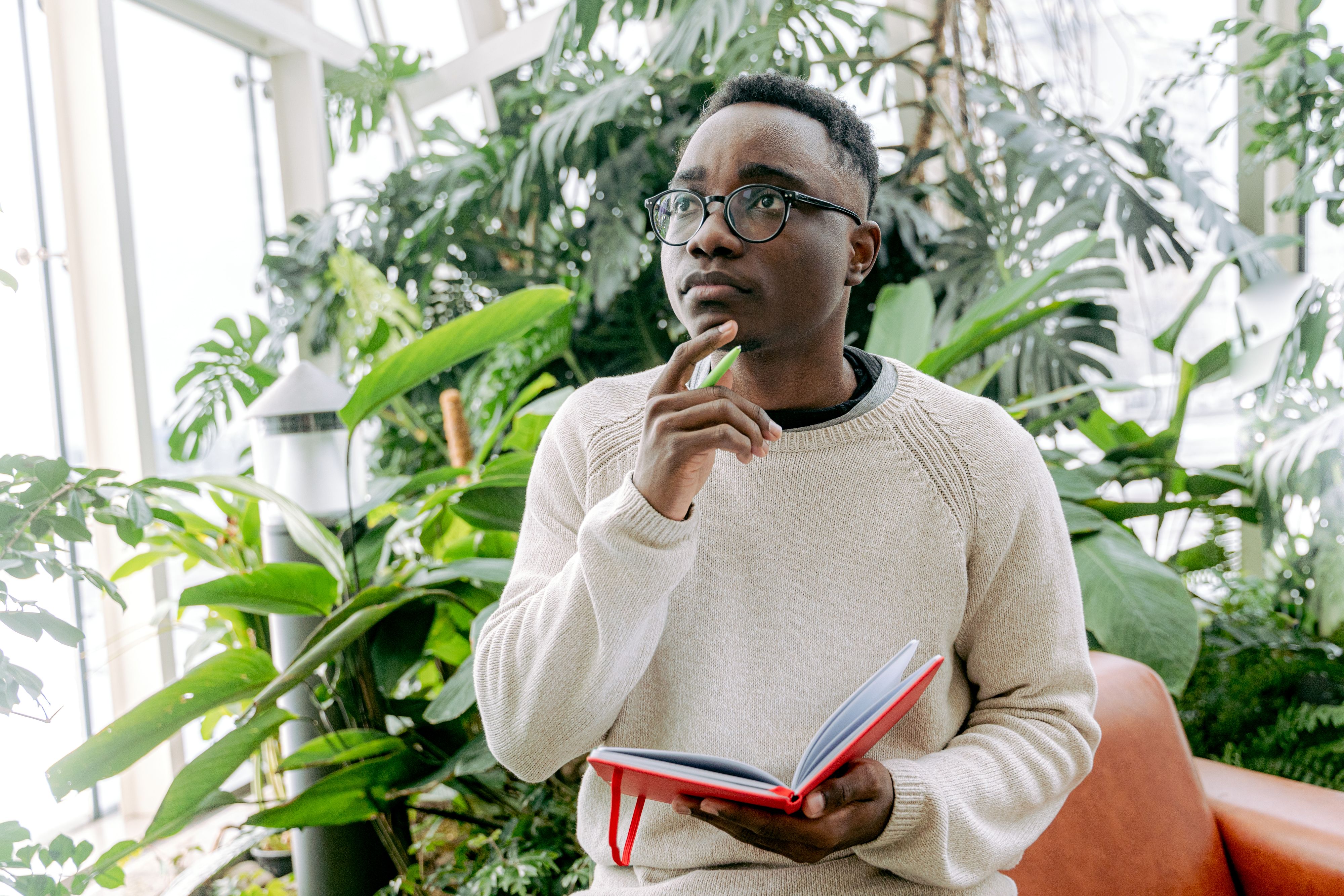 A person thinking while holding a notebook