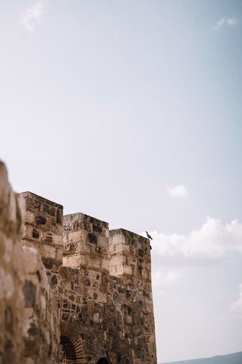 Stone fortress walls beneath a bright blue sky