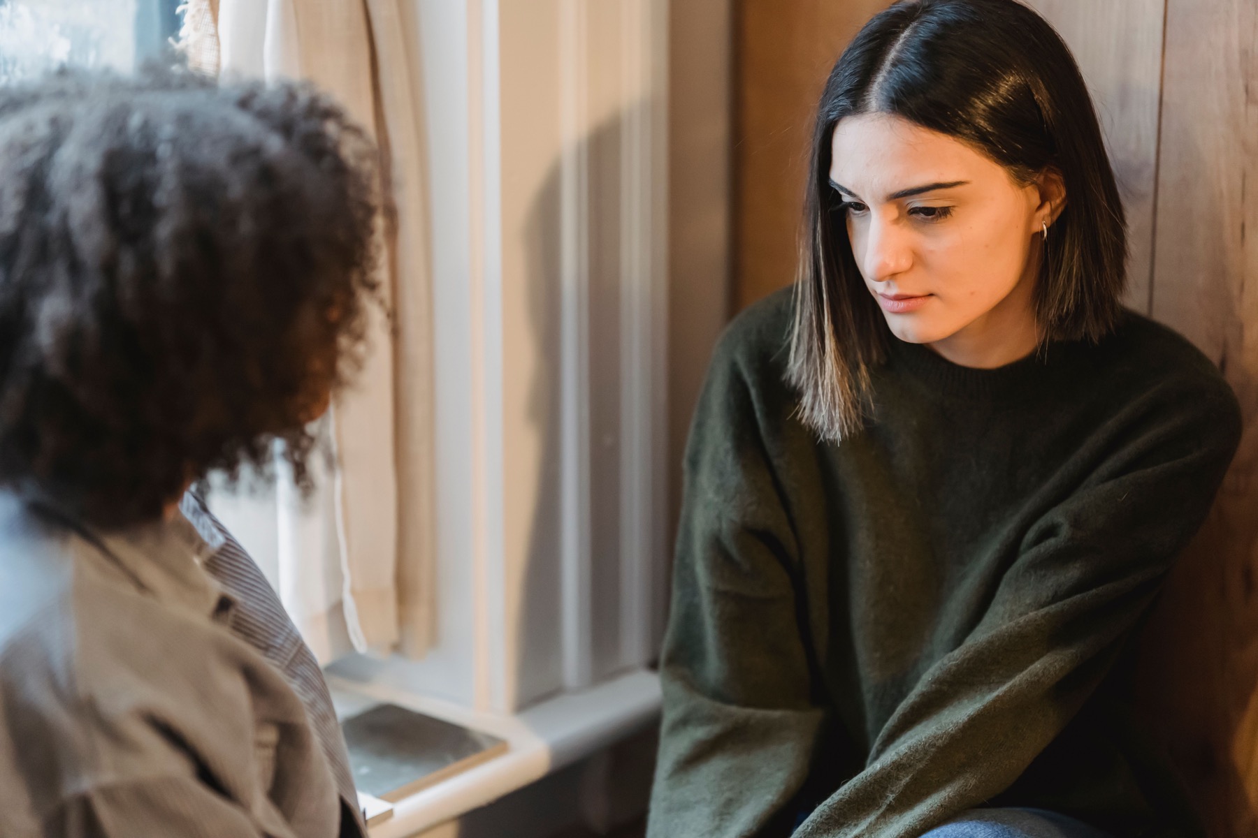 Two friends having a thoughtful conversation indoors