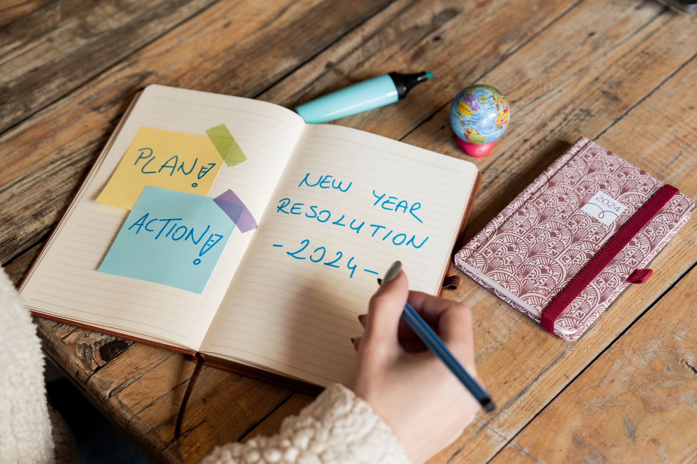 A person writing plans in a notebook