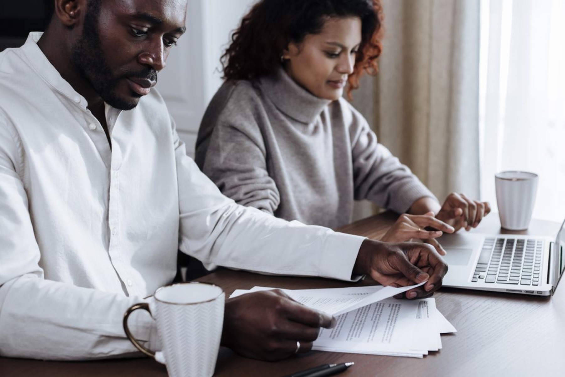 A couple reviewing plans together at a laptop