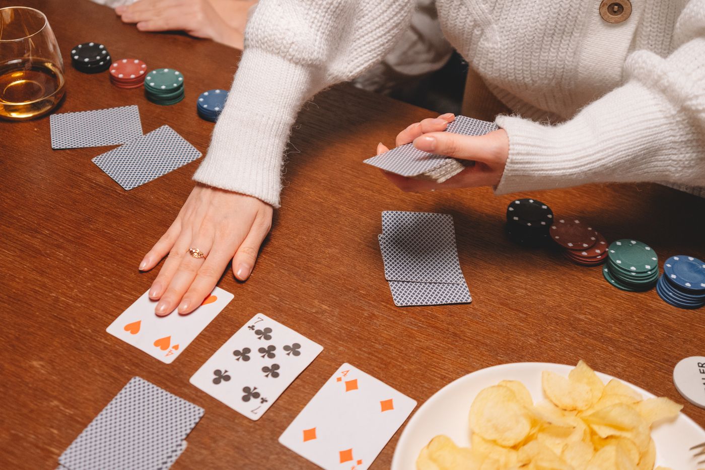 A hand dealing playing cards on a table