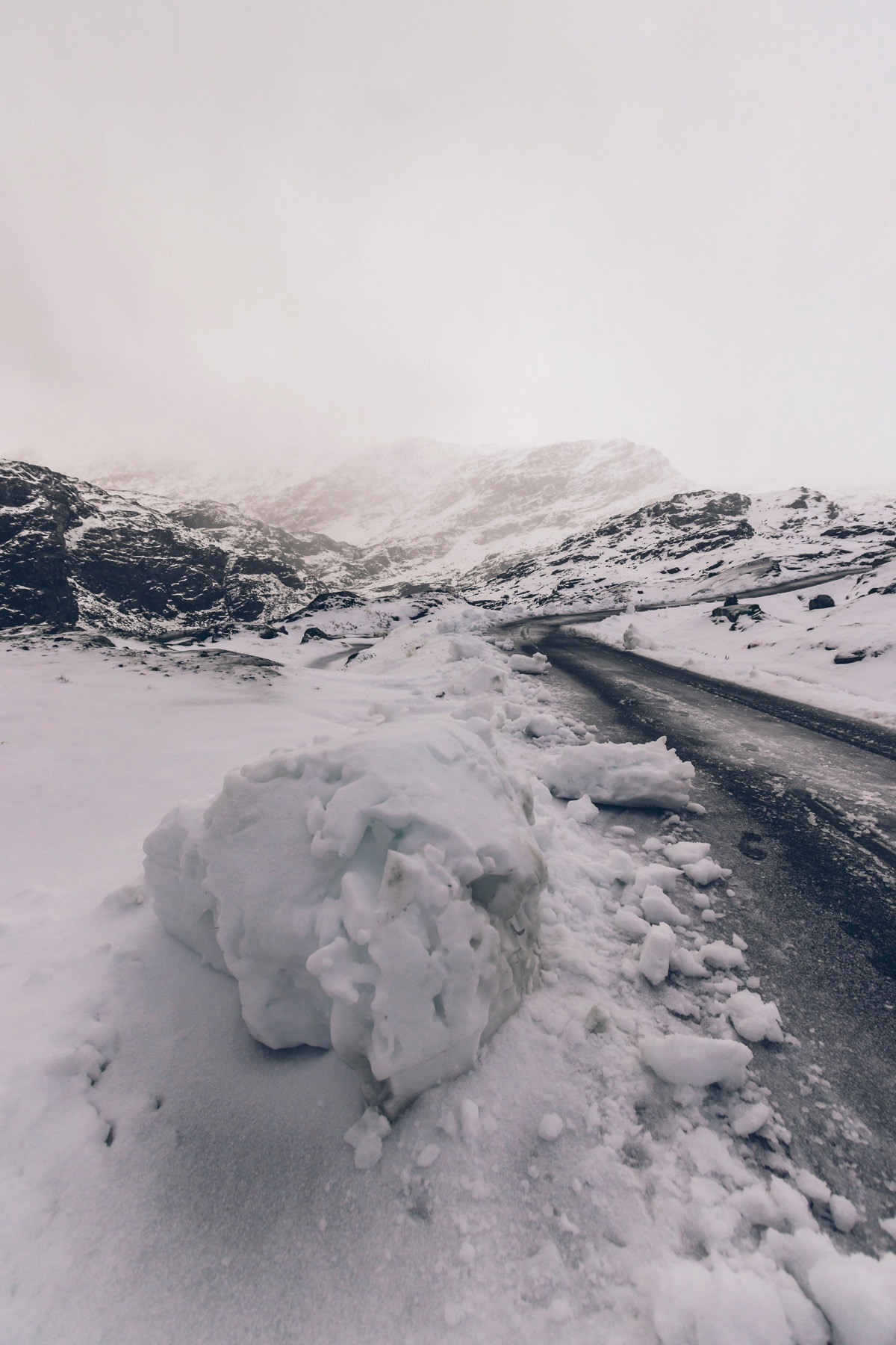 A large snowball beside a snowy road