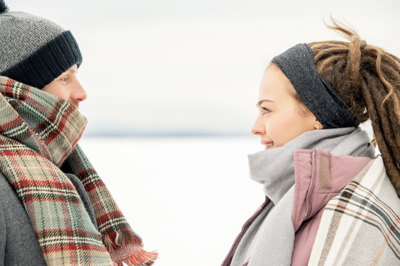 Two people wearing scarves outdoors in winter