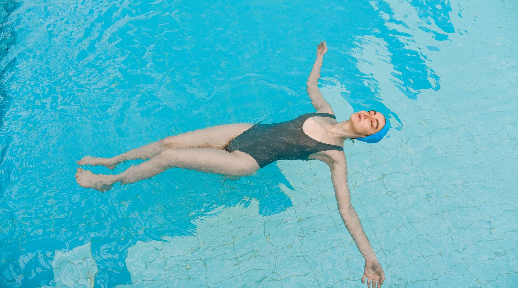 A swimmer floating calmly on blue water