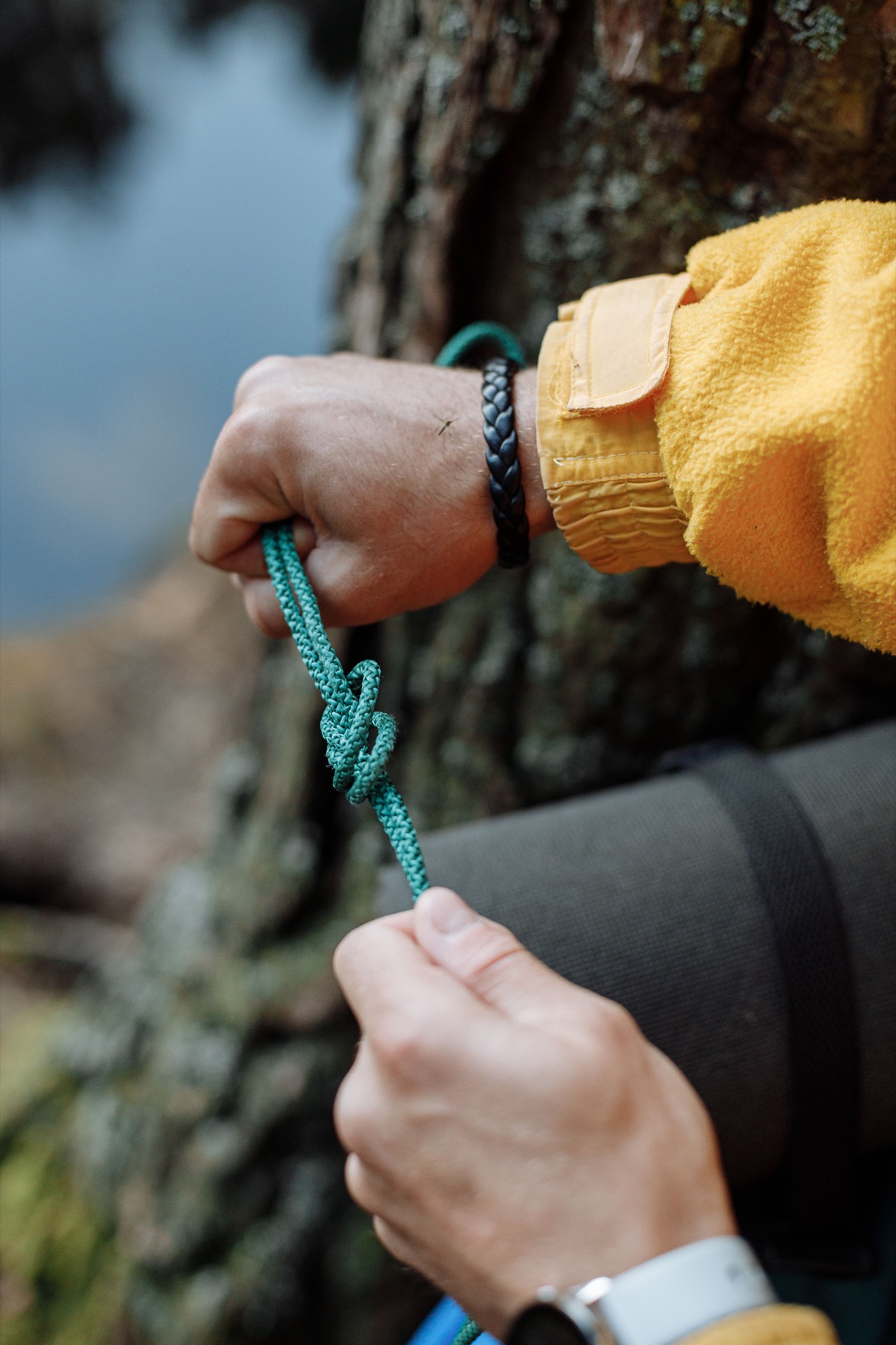 Hands tying a rope knot outdoors
