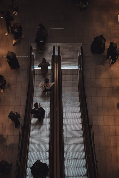 Commuters riding escalators in a Copenhagen subway station