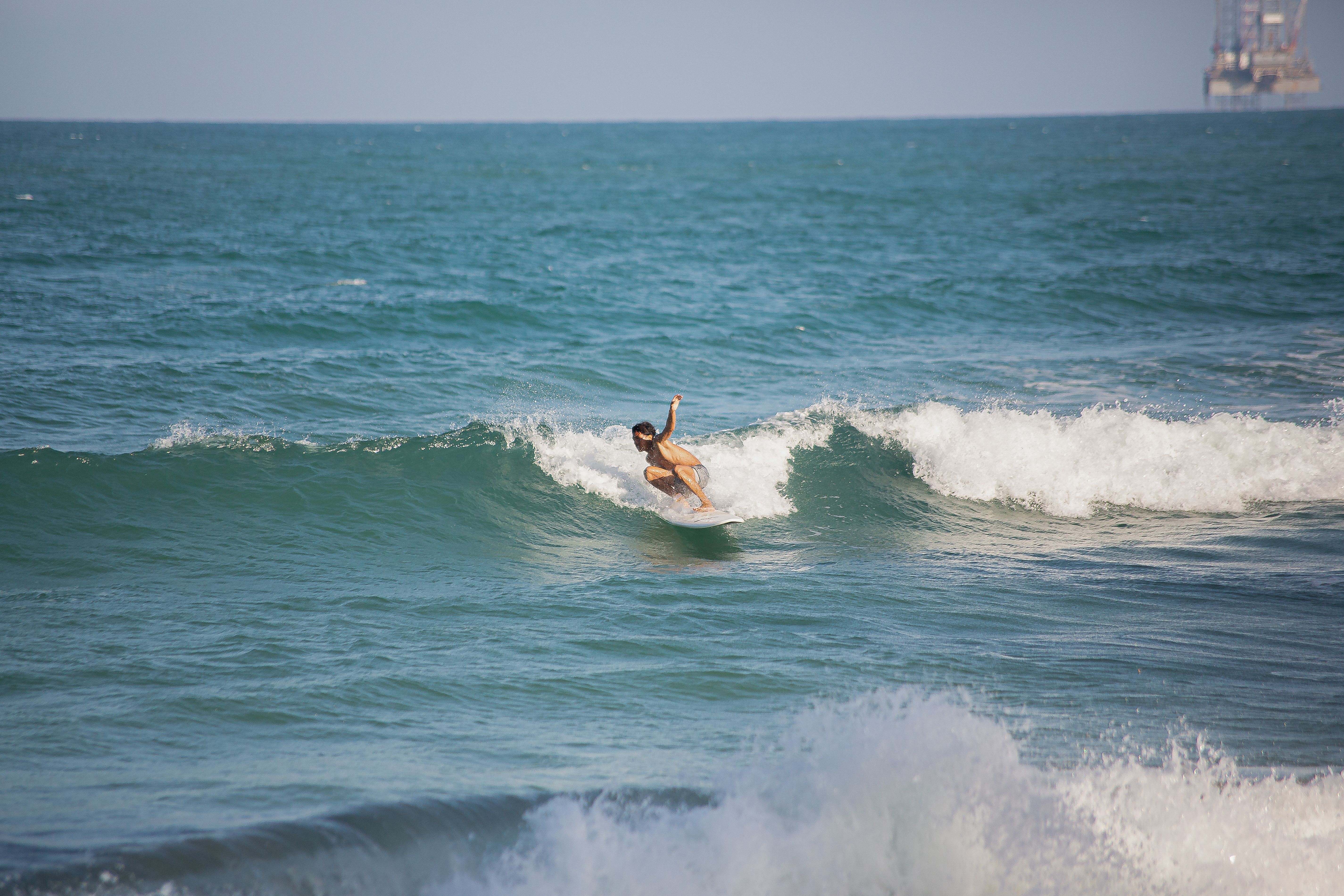 A surfer riding a wave in a blue ocean